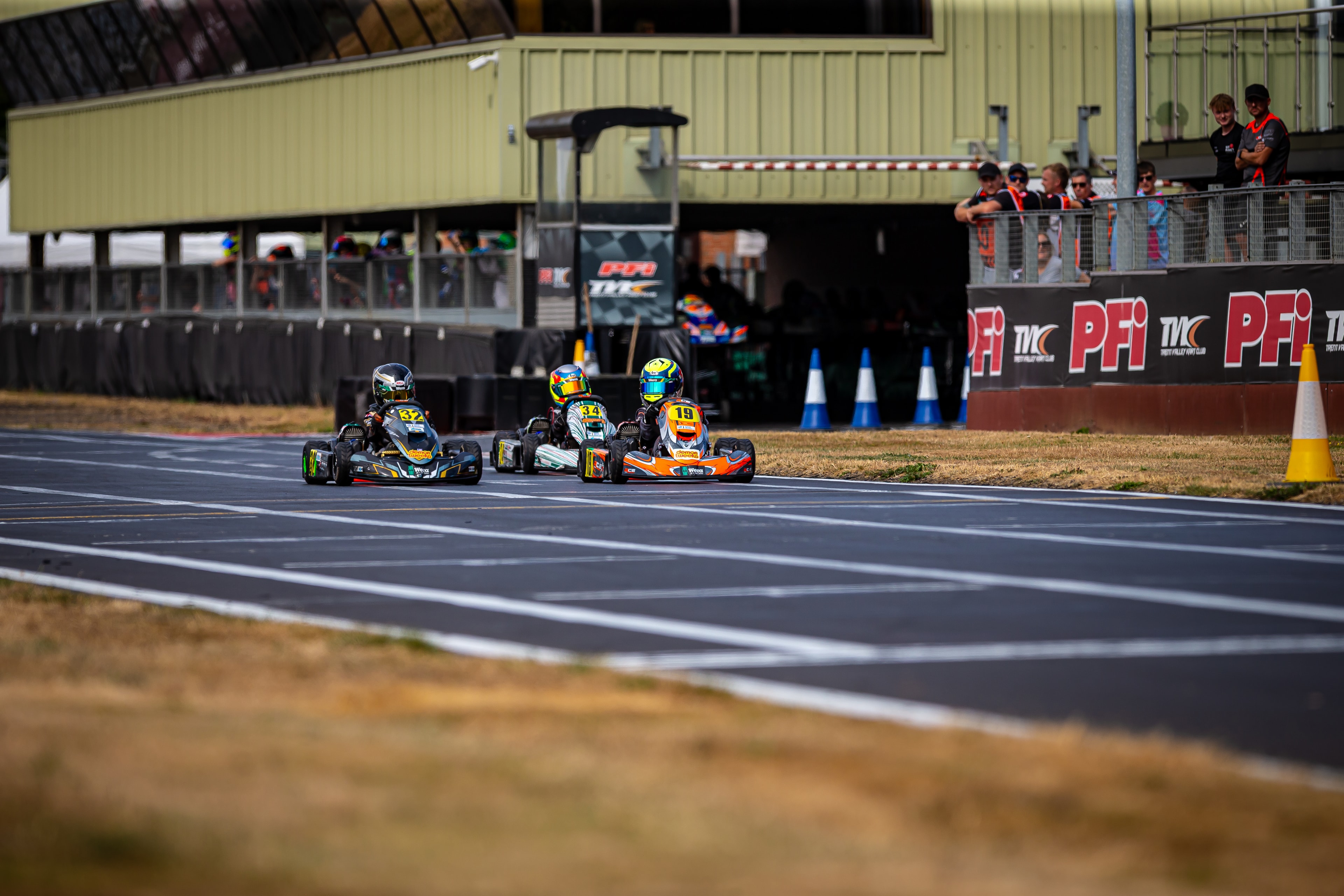 Henry Exton kart number 32 racing at PFI with spectators watching